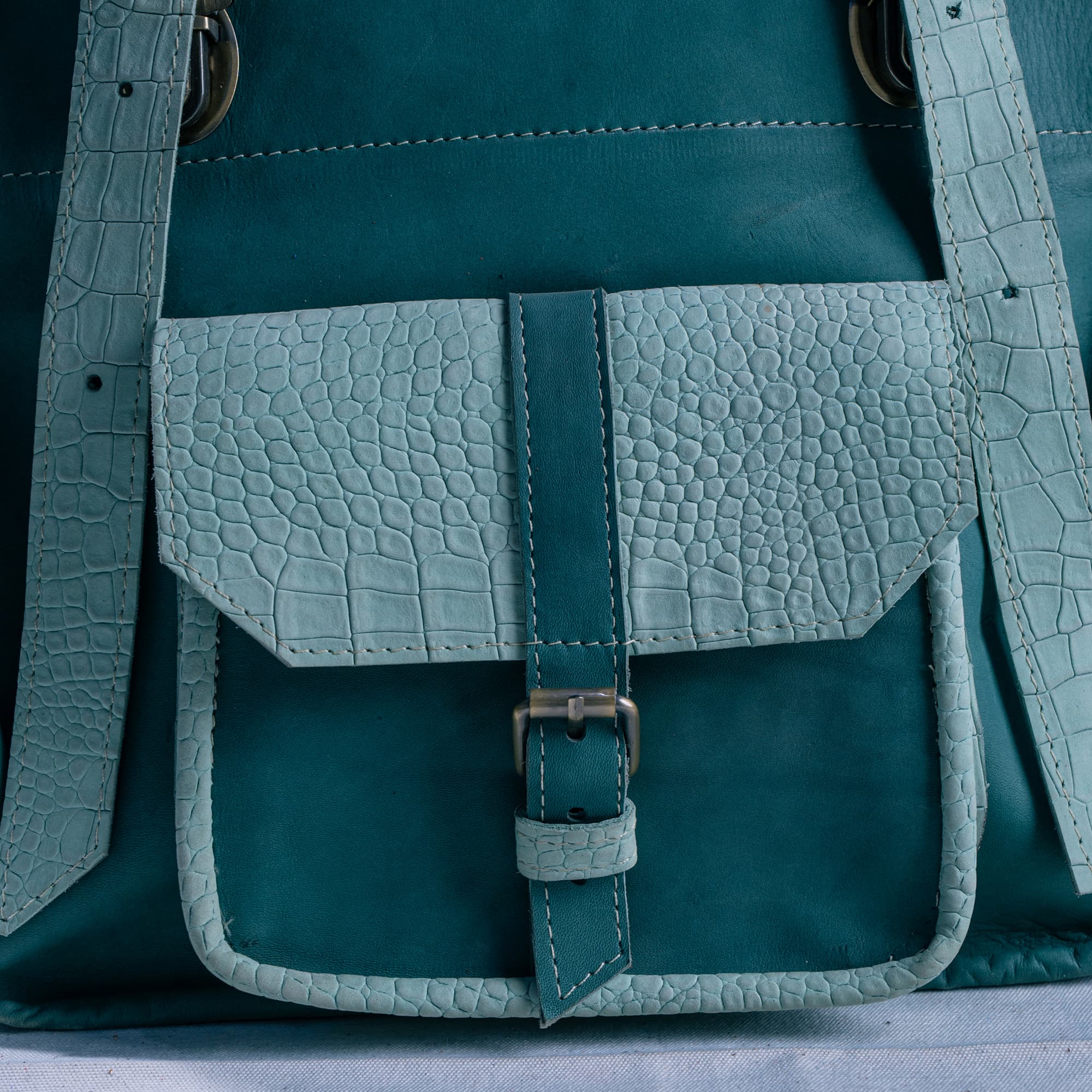 Gros plan sur un sac en cuir patiné bleu-vert
